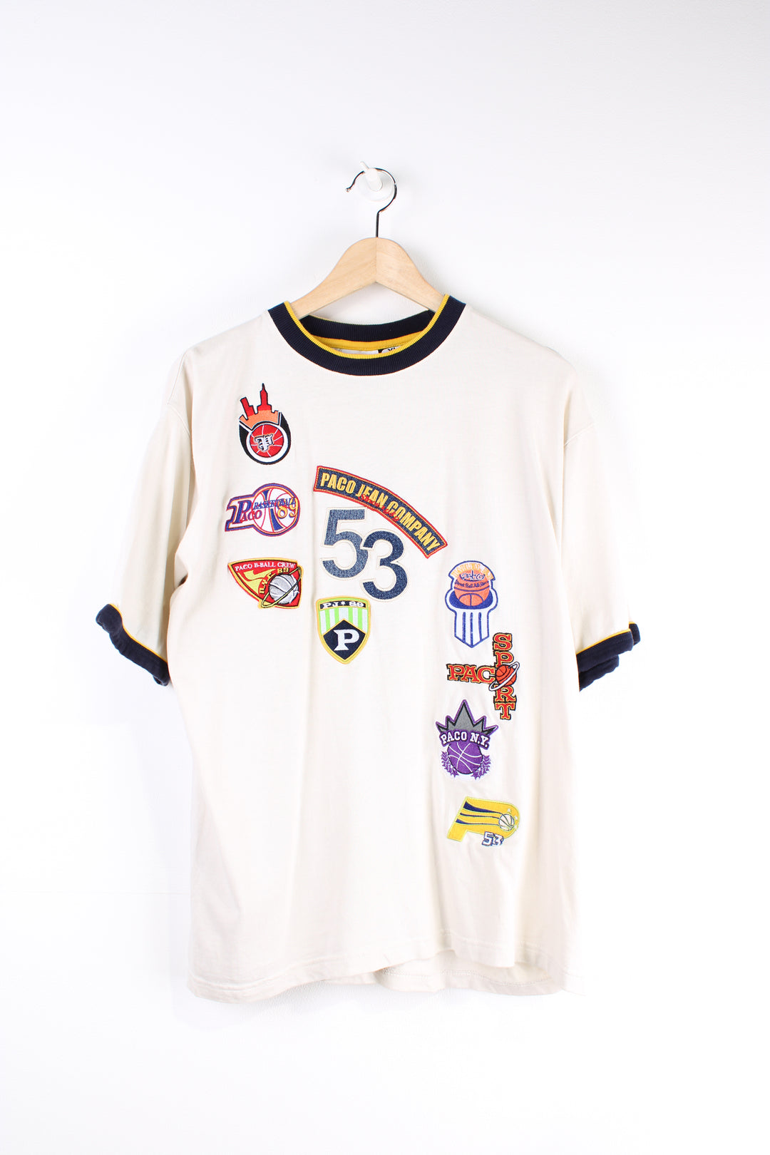 Paco Jean Company cream ringer t-shirt features embroidered badges all over the front