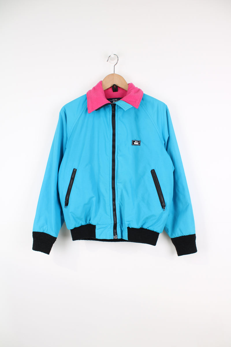 Vintage Woolrich bright blue zip through bomber jacket features black contrast zippers, ,pink fleece lining and logo on the chest