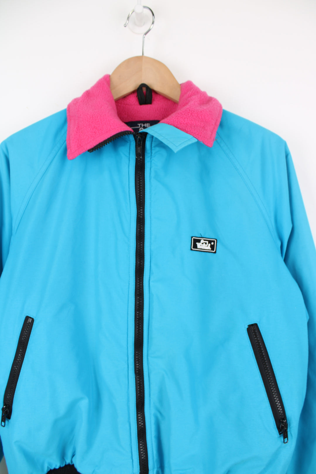 Vintage Woolrich bright blue zip through bomber jacket features black contrast zippers, ,pink fleece lining and logo on the chest