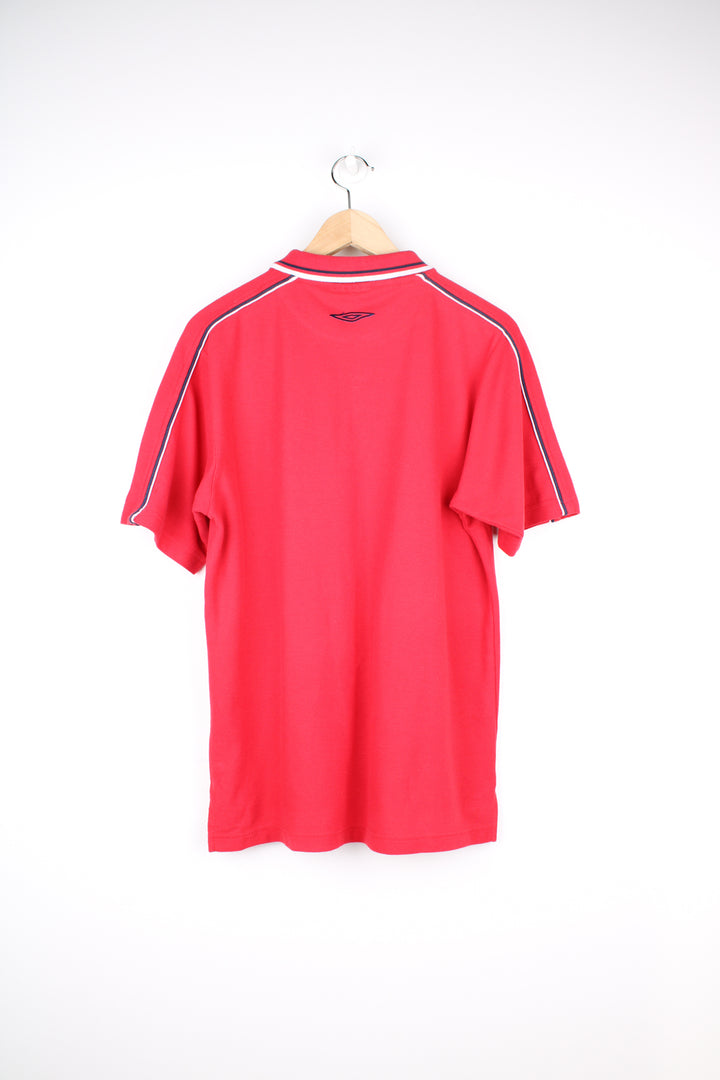 Umbro Polo Shirt in a red colourway with blue and white stripes going round the collar and shoulders, button up collar, short sleeved and has the logo embroidered on the front and back.