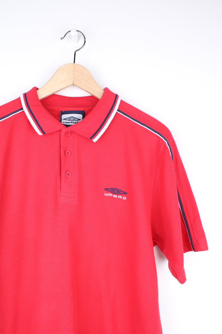 Umbro Polo Shirt in a red colourway with blue and white stripes going round the collar and shoulders, button up collar, short sleeved and has the logo embroidered on the front and back.