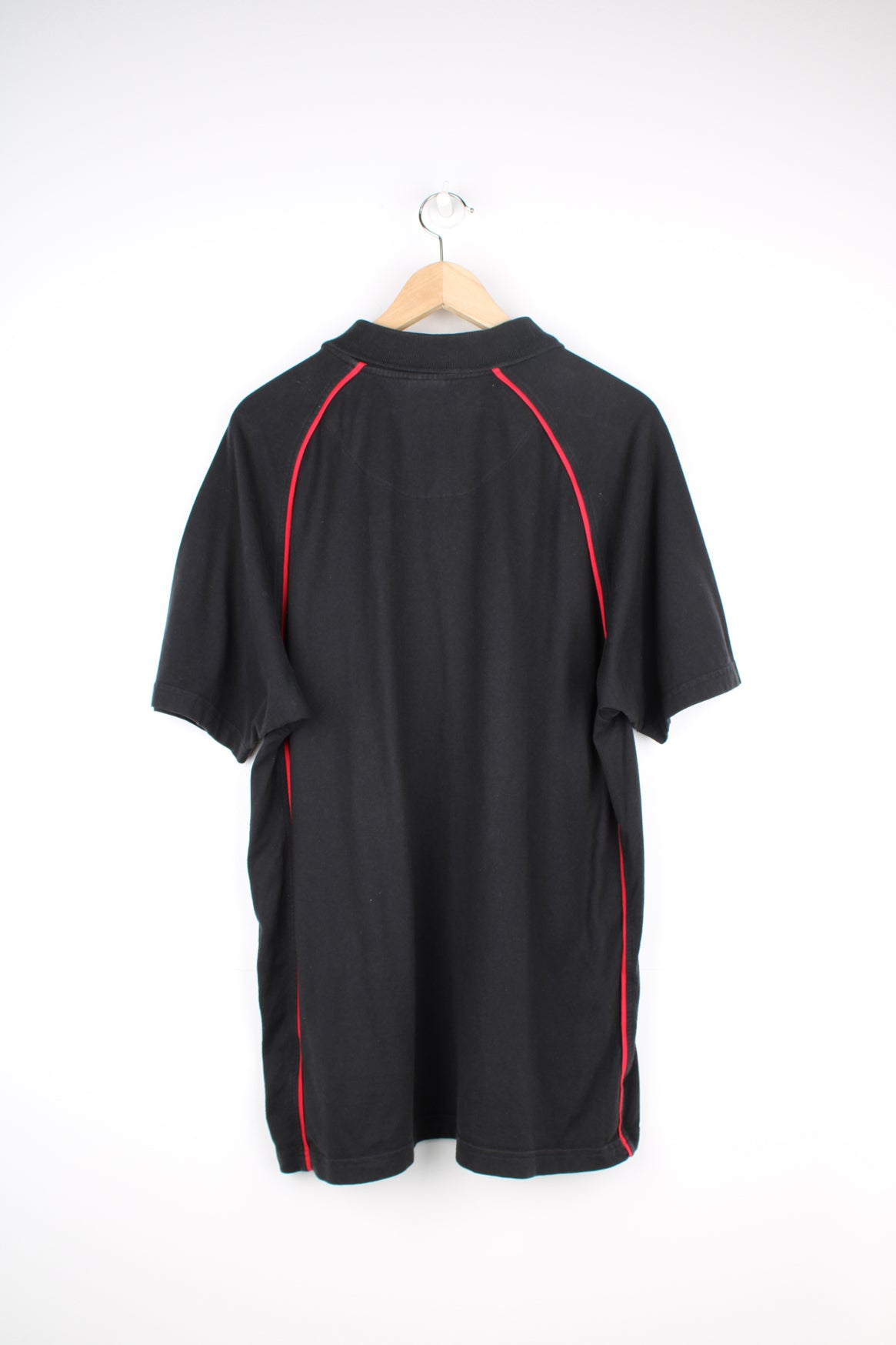 Manchester United, Nike Polo Shirt in a black and red colourway, button up collar, short sleeved and has the logos embroidered on the front.