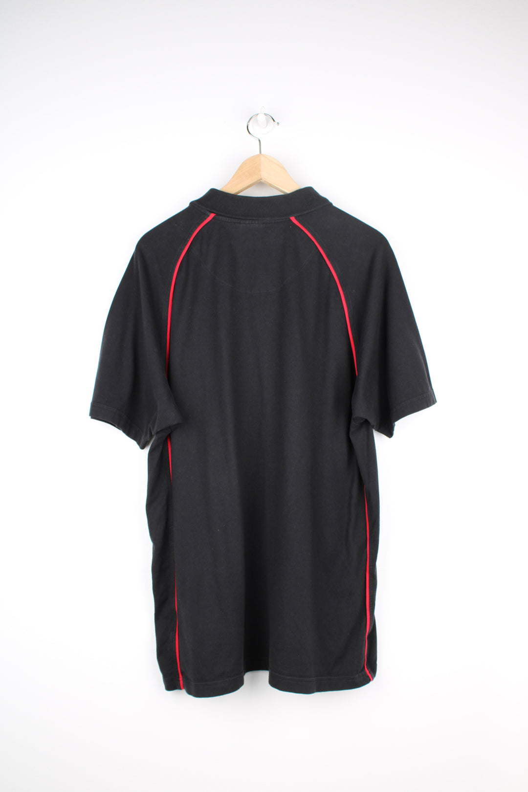 Manchester United, Nike Polo Shirt in a black and red colourway, button up collar, short sleeved and has the logos embroidered on the front.