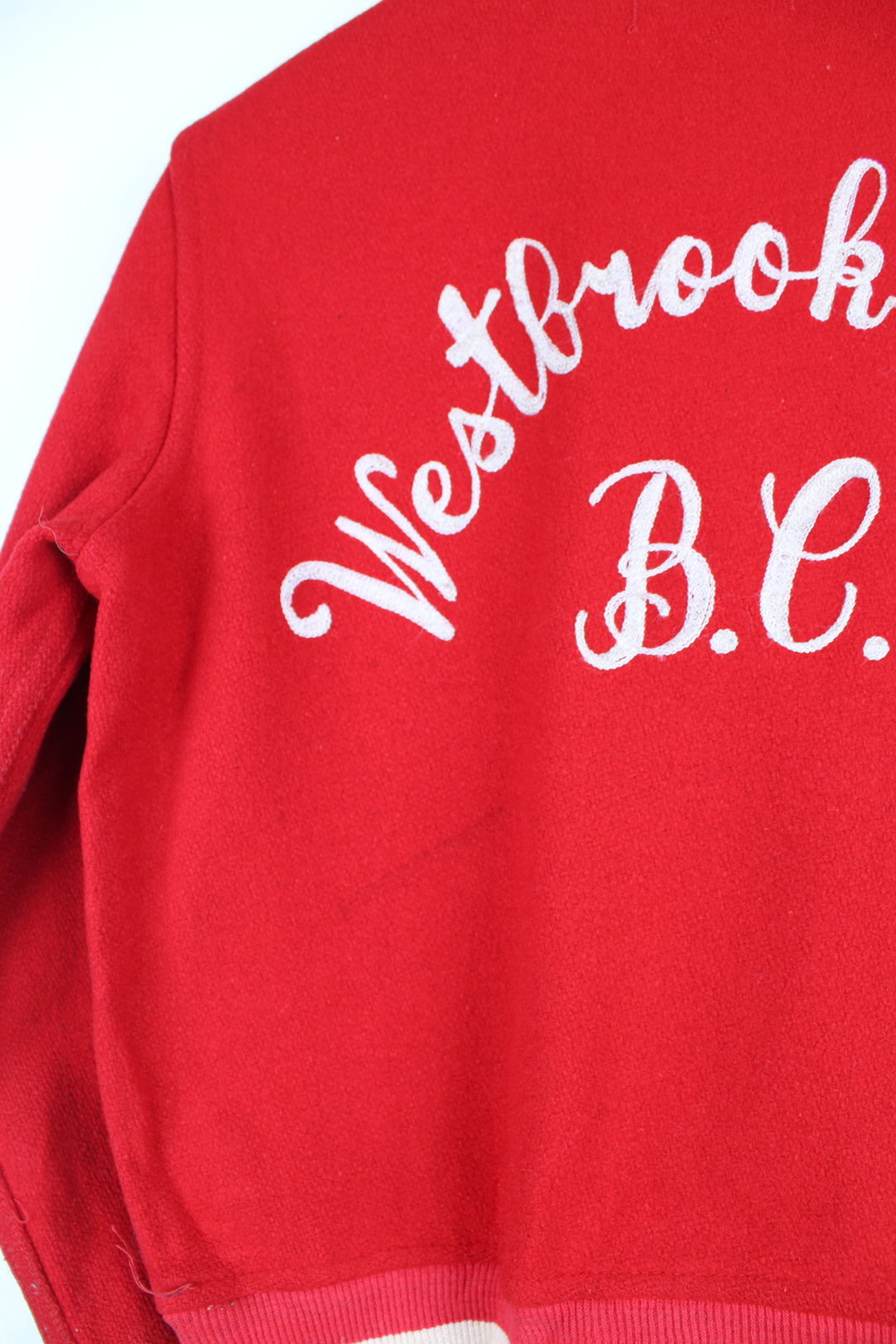 Vintage 60's Woollen Varsity Jacket in a red and white colourway, button up with side pockets, and has 'Mark' embroidered on the front as well as 'Westbrook Park B.C.' embroidered spell out on the back.