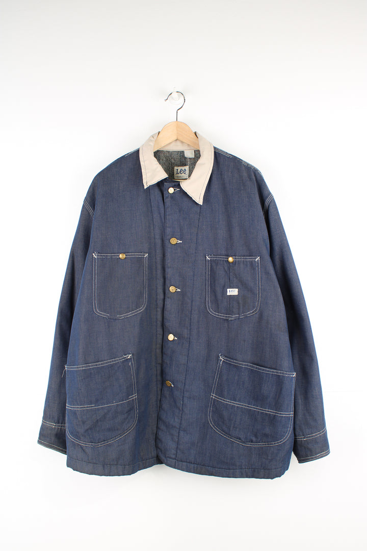 Vintage 70's Lee Denim Chore Jacket in a dark blue colourway with a tanned collar and contrast stitching throughout, button up with multiple pockets, blanket lining, and has the logo embroidered on the front.