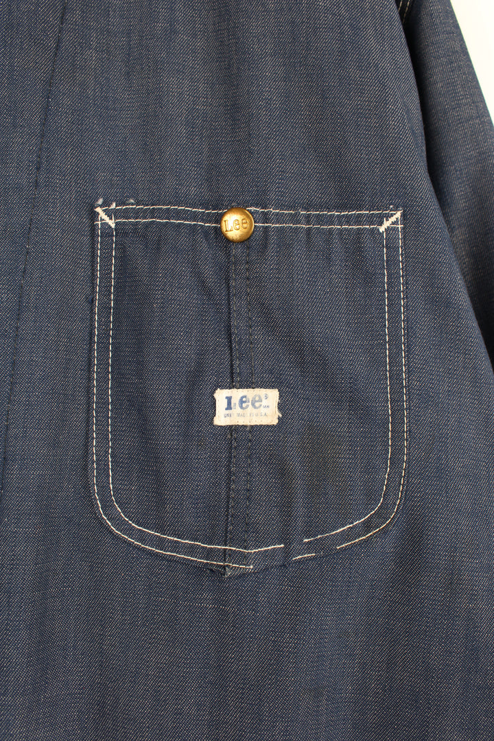 Vintage 70's Lee Denim Chore Jacket in a dark blue colourway with a tanned collar and contrast stitching throughout, button up with multiple pockets, blanket lining, and has the logo embroidered on the front.