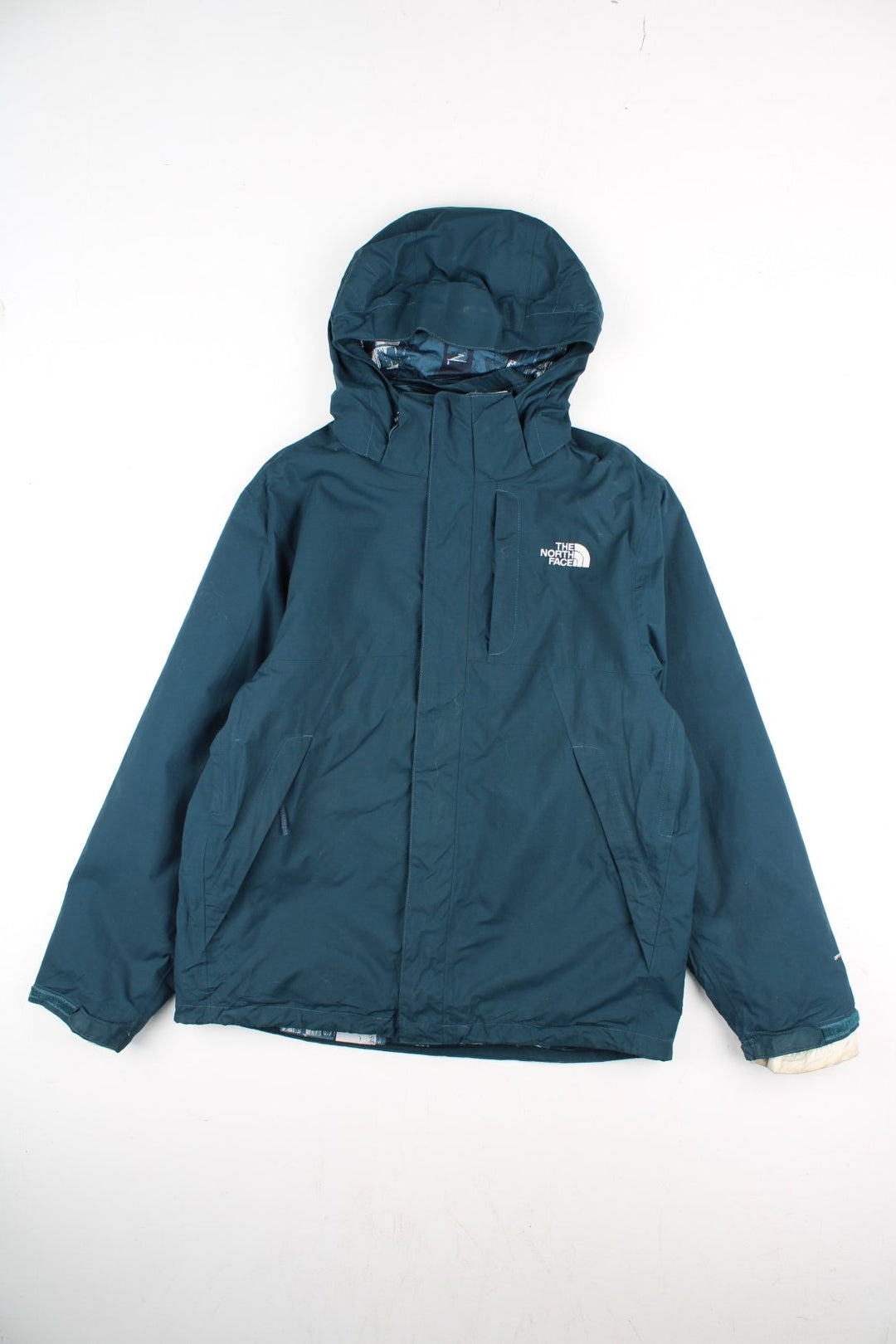 The North Face 2 in 1 Dryvent Jacket in a blue colourway. Zips up and has multiple pockets, detachable gilet lining, hooded, and has the logo embroidered on the front and back.