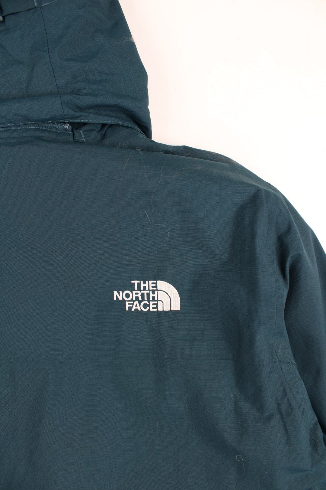 The North Face 2 in 1 Dryvent Jacket in a blue colourway. Zips up and has multiple pockets, detachable gilet lining, hooded, and has the logo embroidered on the front and back.