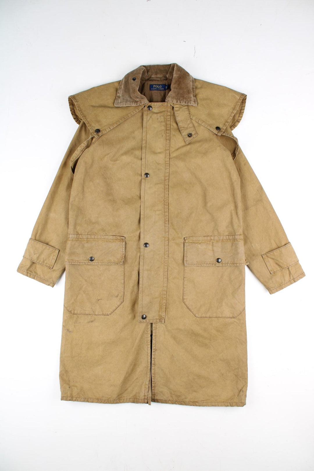 Vintage Polo Ralph Lauren Duster Trench Coat in a tan colourway. Zips and buttons up, has double pockets, corduroy collar, and has a cape feature on the back.