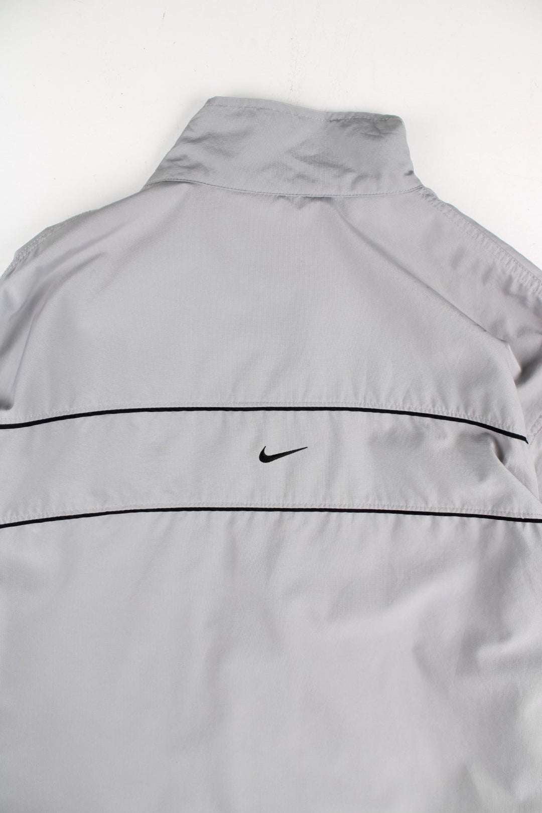 Y2K Nike Tracksuit Jacket in a grey colourway. Zips up and has side pockets, mesh lining, and has the swoosh logo embroidered on the front and back.