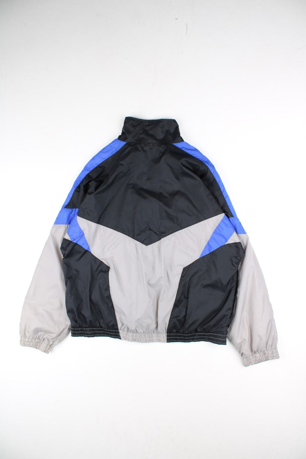 Vintage 90's Nike Tracksuit Jacket in a black, grey and blue patterned colourway. Zips up and has side pockets, and has the logo embroidered on the front.