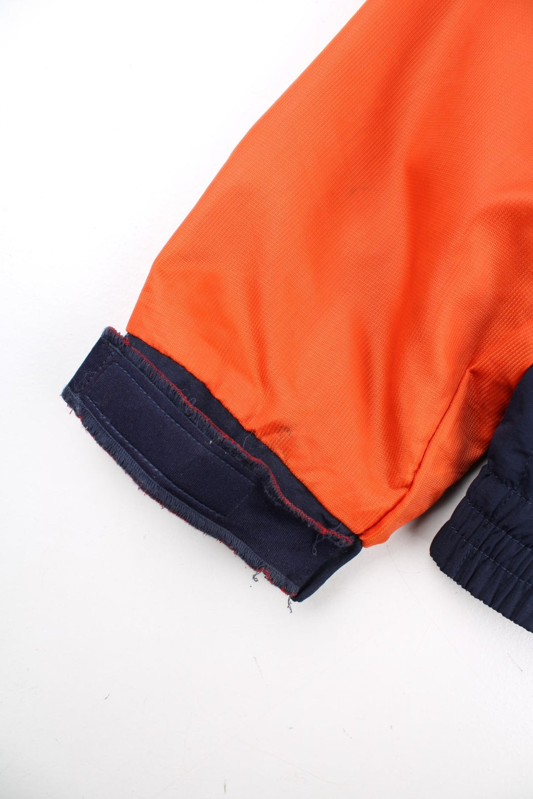 Vintage Tommy Hilfiger Windbreaker Jacket in a orange and blue colourway. Zips up and has side pockets, mesh lining, has the logo stripe going across the front and back, and the spell out embroidered on the left sleeve.