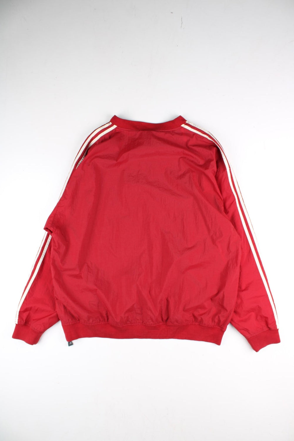 Vintage 90's Adidas Drill Training Top in a red colourway, has the iconic three stripes going down the sleeves, and on the front the logo embroidered on.