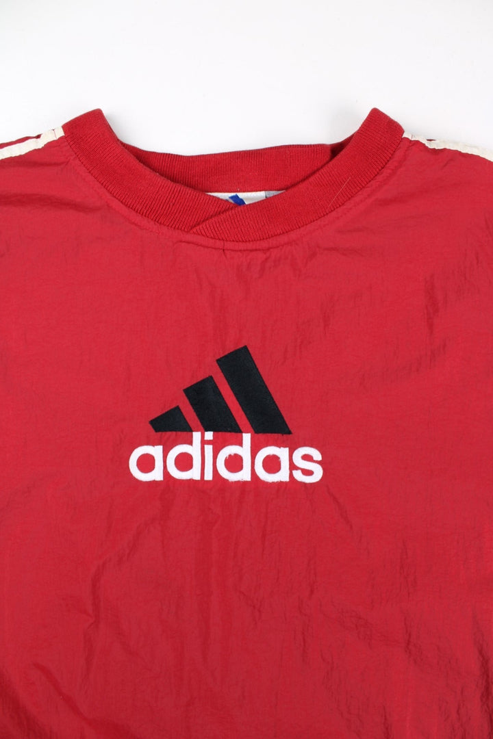 Vintage 90's Adidas Drill Training Top in a red colourway, has the iconic three stripes going down the sleeves, and on the front the logo embroidered on.