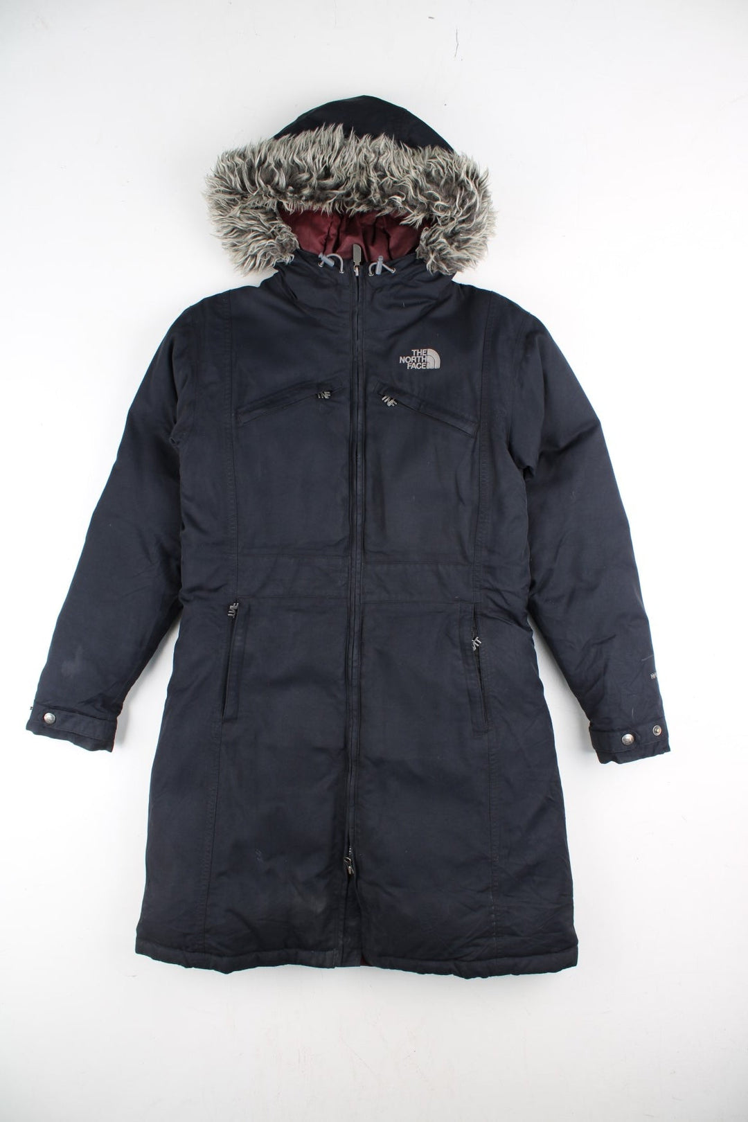 The North Face Parka Coat in a black colourway. Zips up and has multiple pockets, insulated lining, hooded with a faux fur trim, and has the logo embroidered on the front and back.