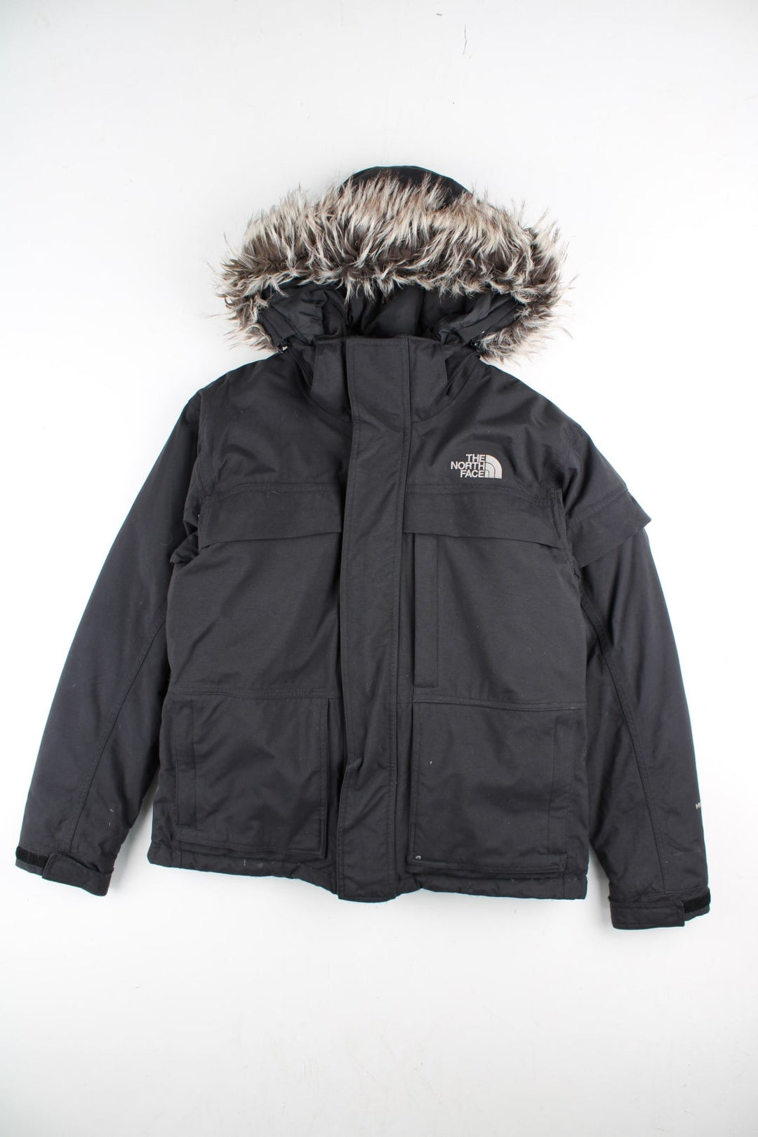 The North Face Parka Coat in a black colourway. Zips up and has multiple pockets, insulated lining, hooded with a detachable faux fur trim, and has the logo embroidered on the front and back.