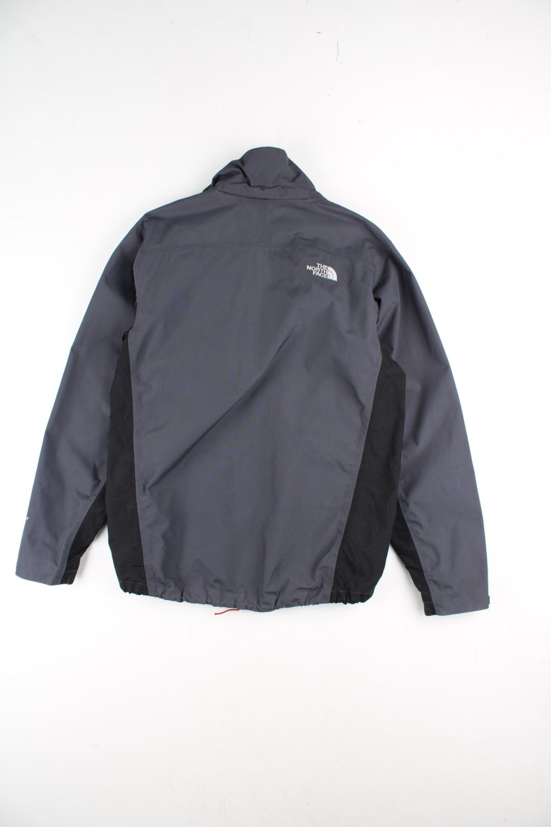 The North Face Jacket in a grey and black colourway. Zips up and has multiple pockets, and the logo embroidered on the front and back.