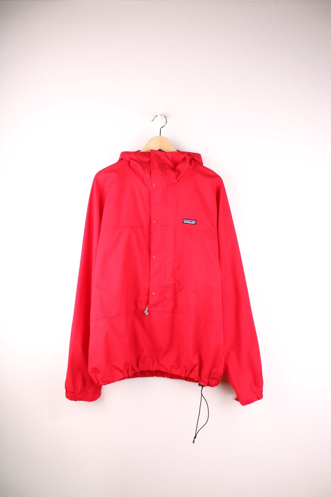 Patagonia lightweight hooded waterproof pullover jacket in red with 3/4 zip and snap closure.