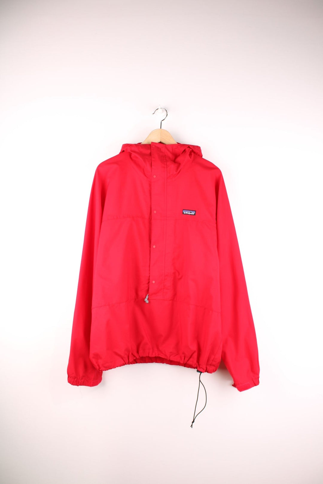 Patagonia lightweight hooded waterproof pullover jacket in red with 3/4 zip and snap closure.