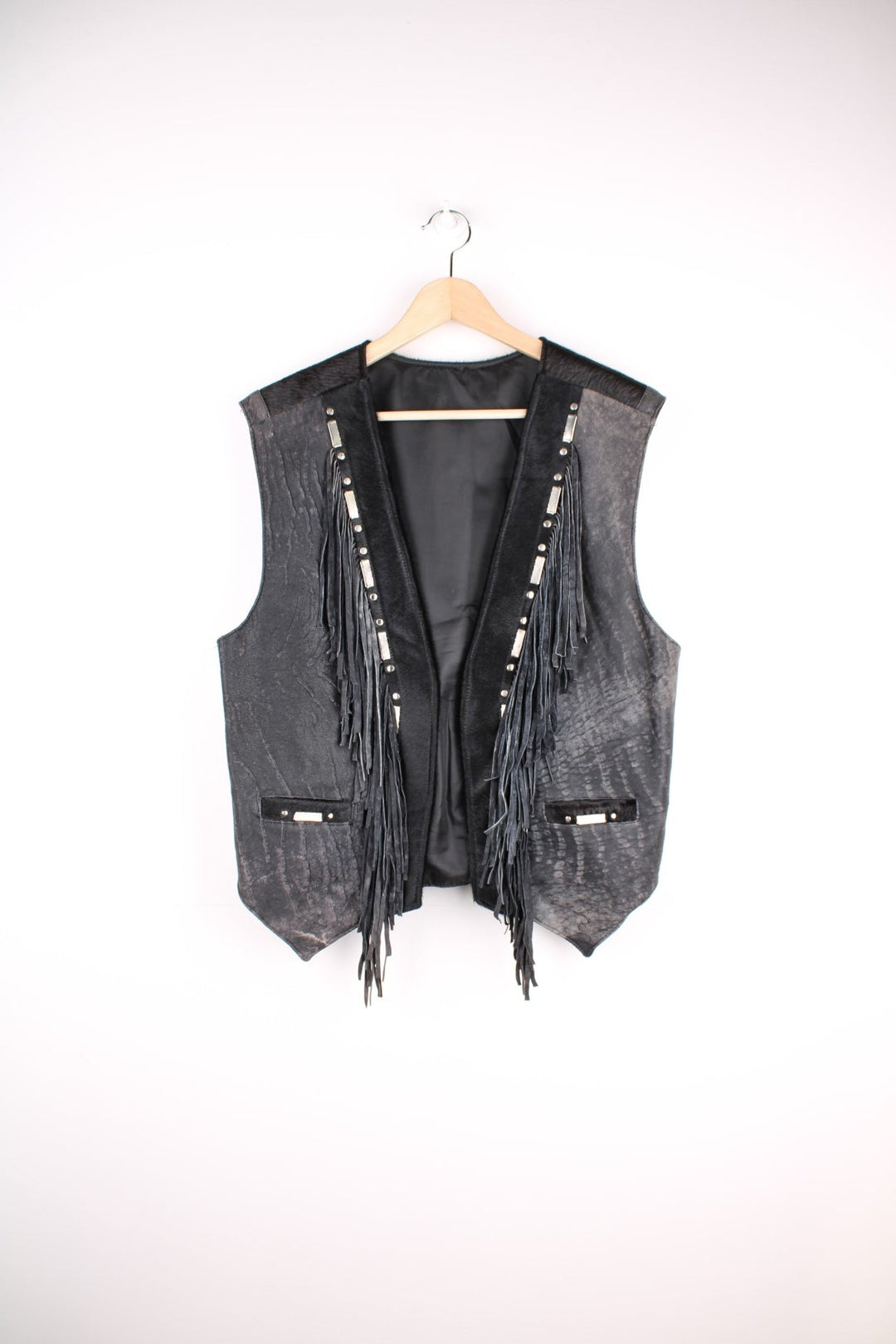 Vintage Leather Gilet in a black colourway with fringing, silver studs/cabochons and an animal hide trim. The gilet has some intentional wear to the leather, as seen in photos.  