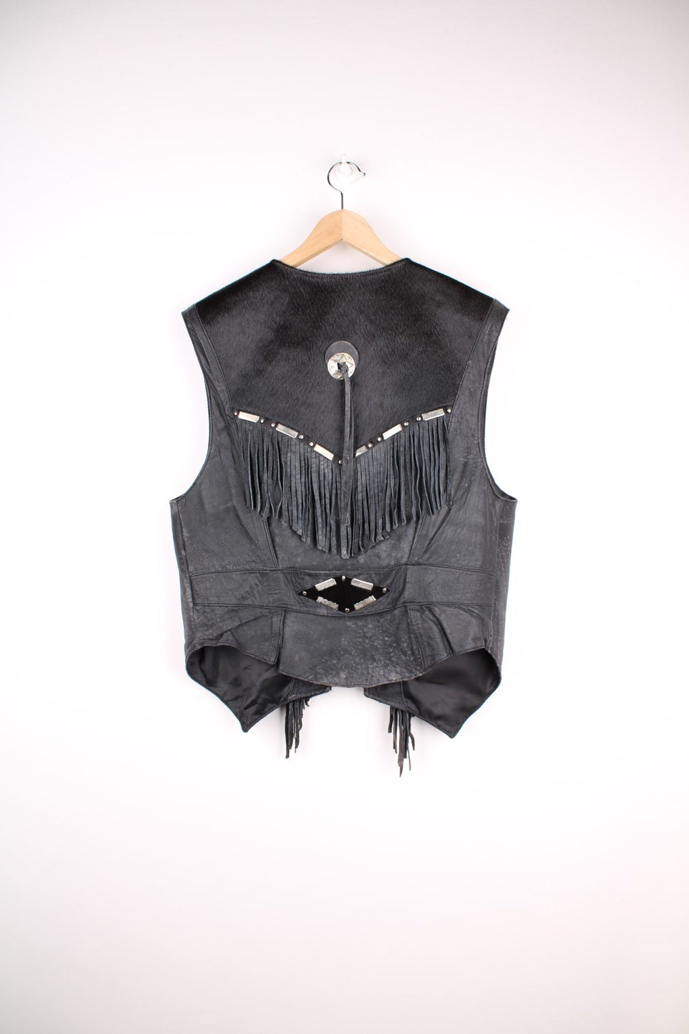 Vintage Leather Gilet in a black colourway with fringing, silver studs/cabochons and an animal hide trim. The gilet has some intentional wear to the leather, as seen in photos.  