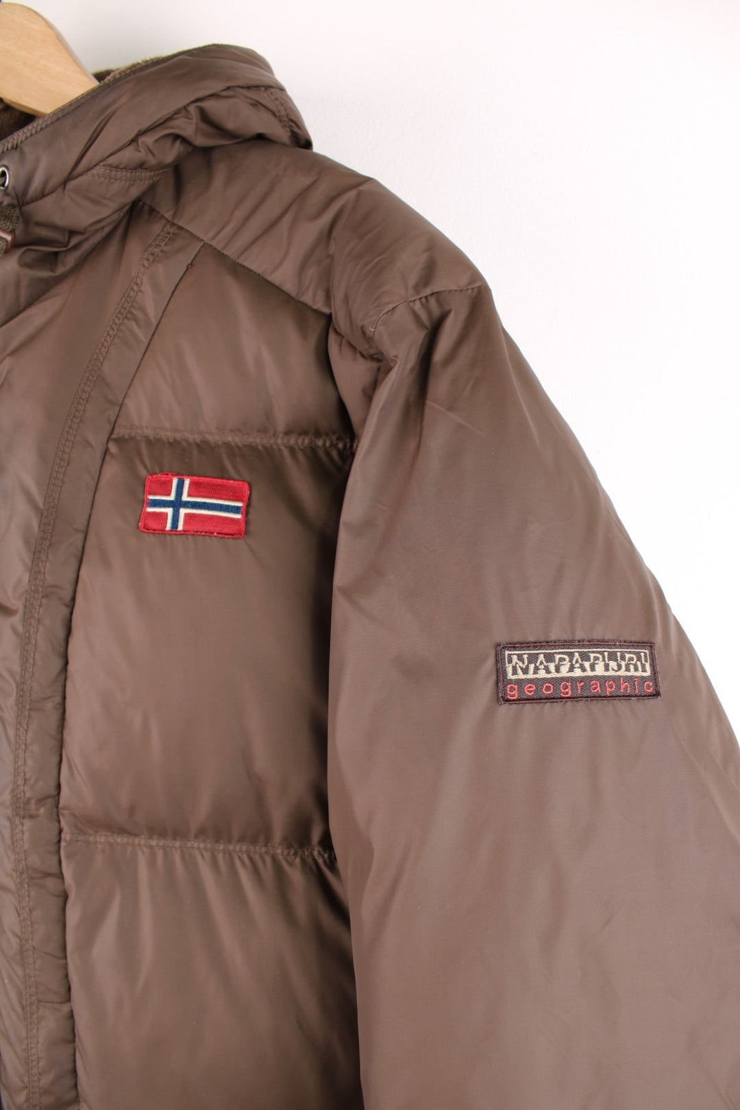 Napapijri puffer coat in khaki green with zip closure, two front pockets and an inside pocket, a hood, a Norway flag patch on the chest and logo on the sleeve.