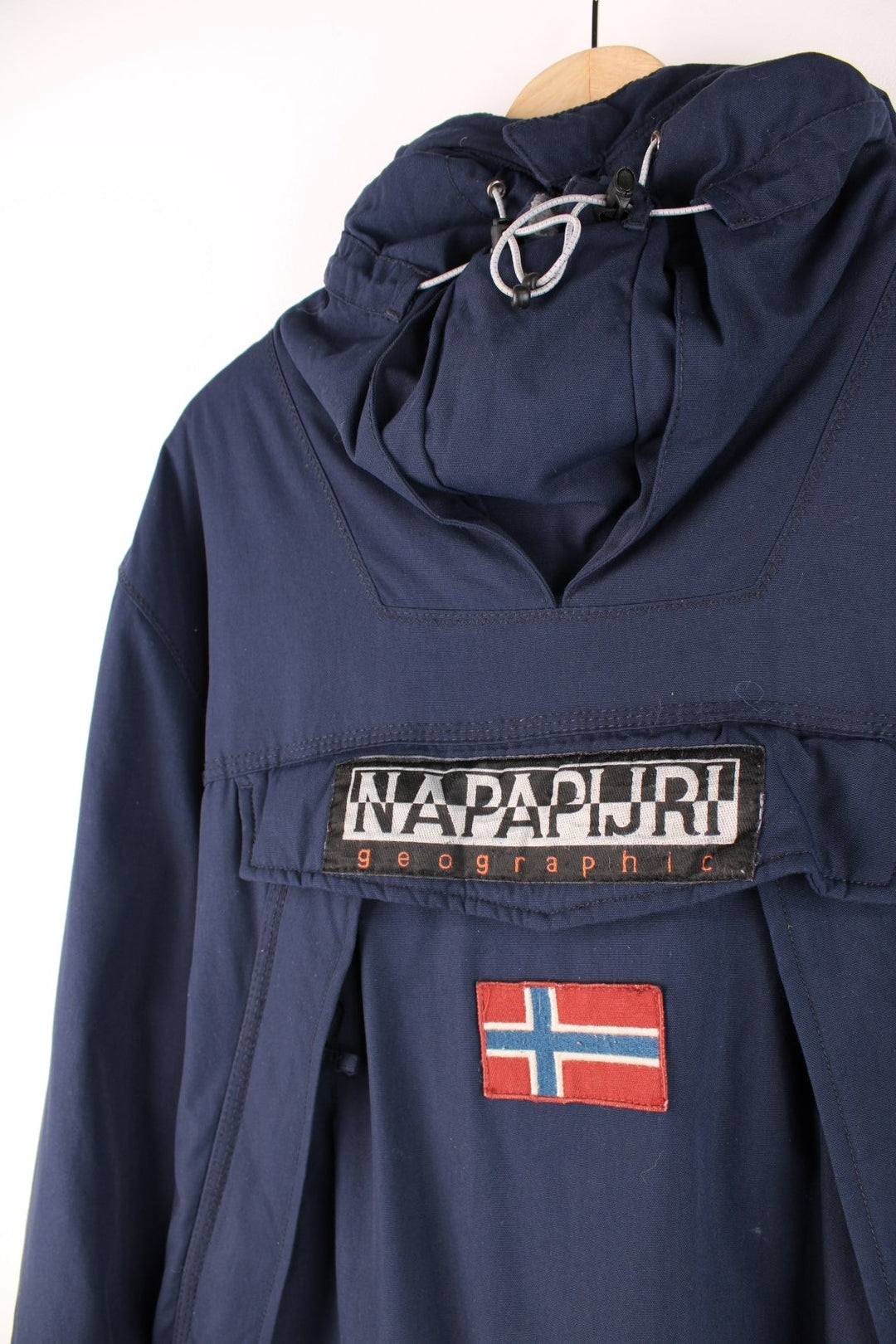 Napapijri Geographic hooded pullover in navy blue with quilted lining, multiple pockets, toggle adjusters, and a side zip.