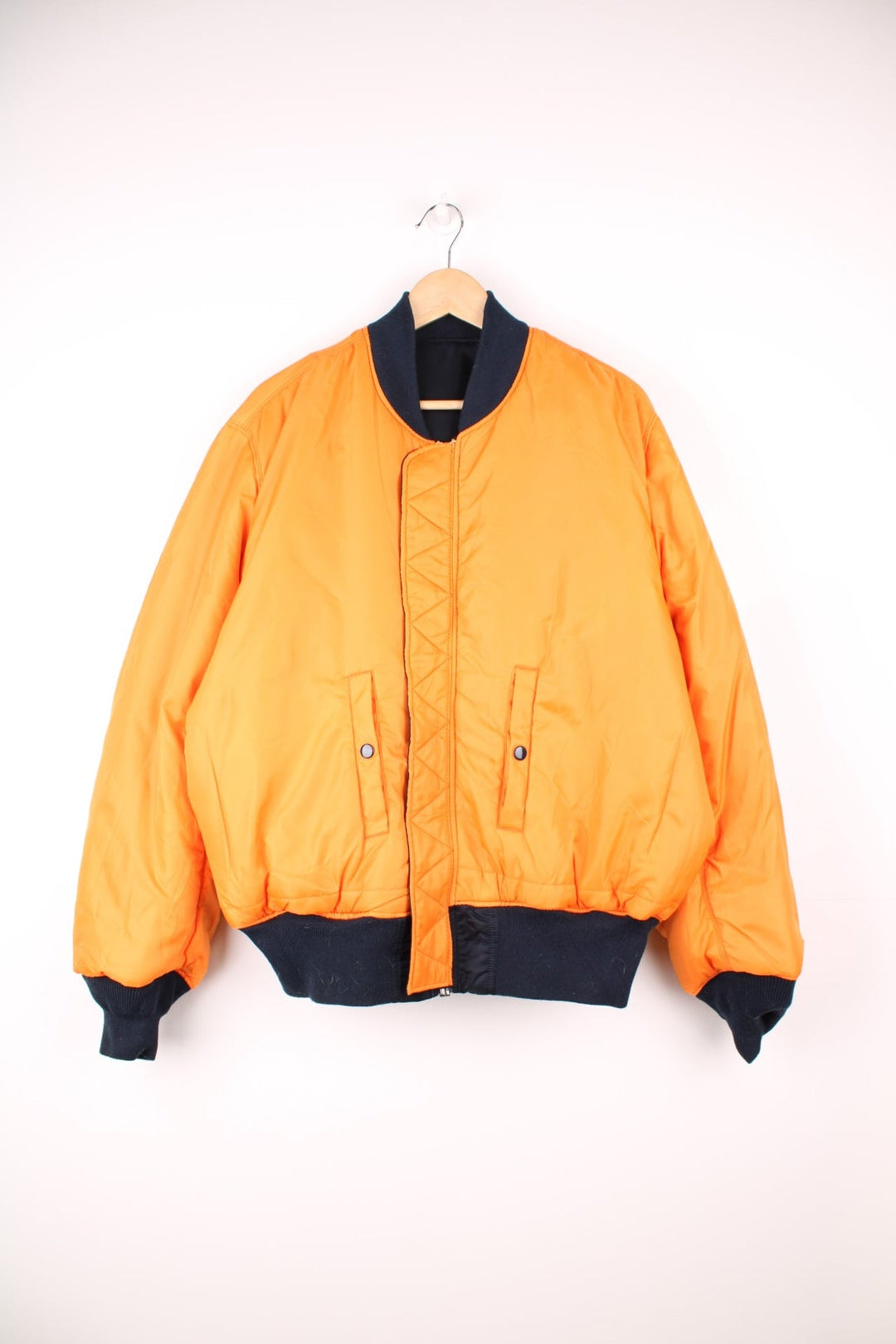 Alpha Industries MA-1 bomber flight reversible jacket in navy blue and orange with elasticated waistband and cuffs.