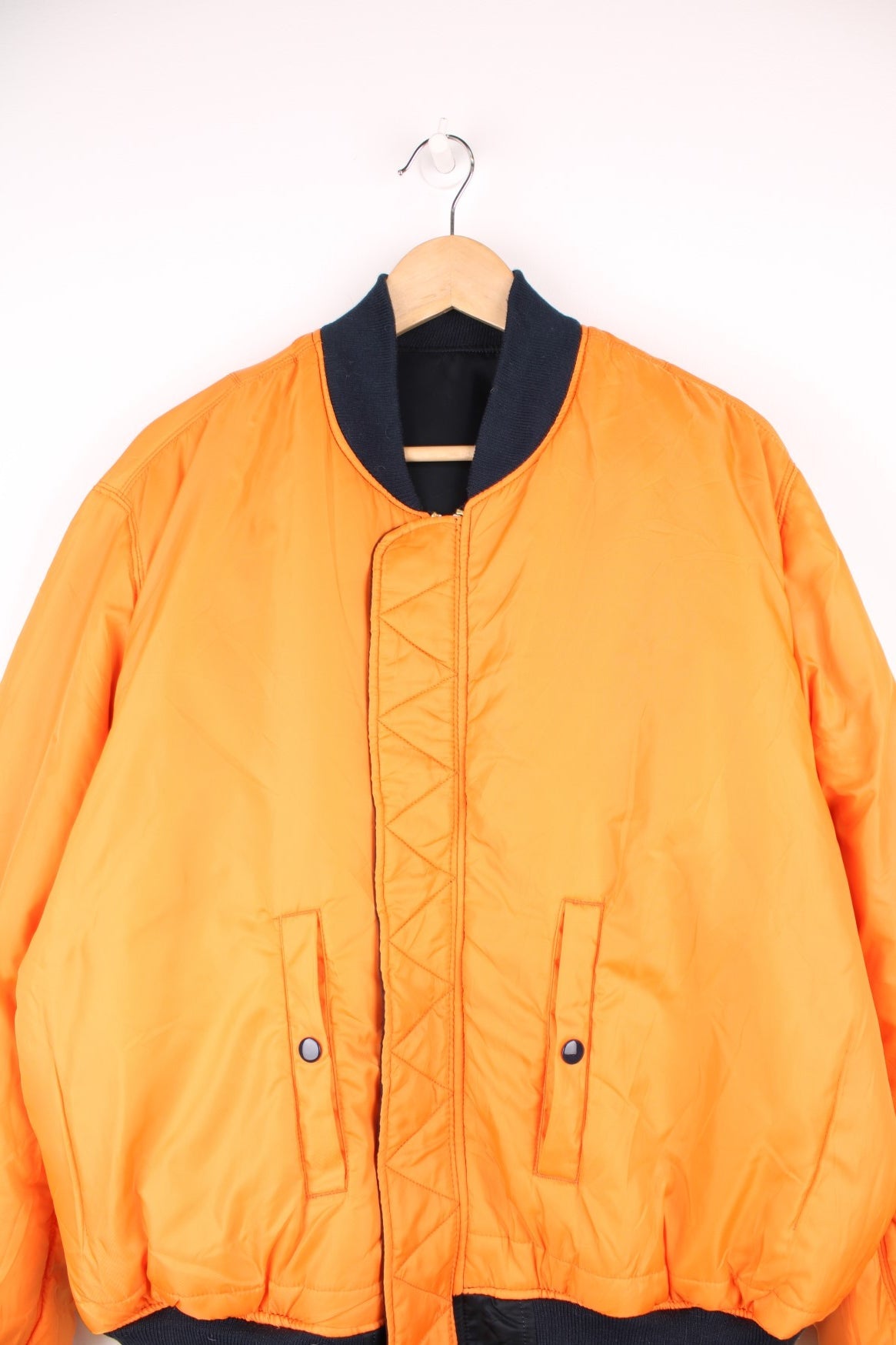 Alpha Industries MA-1 bomber flight reversible jacket in navy blue and orange with elasticated waistband and cuffs.