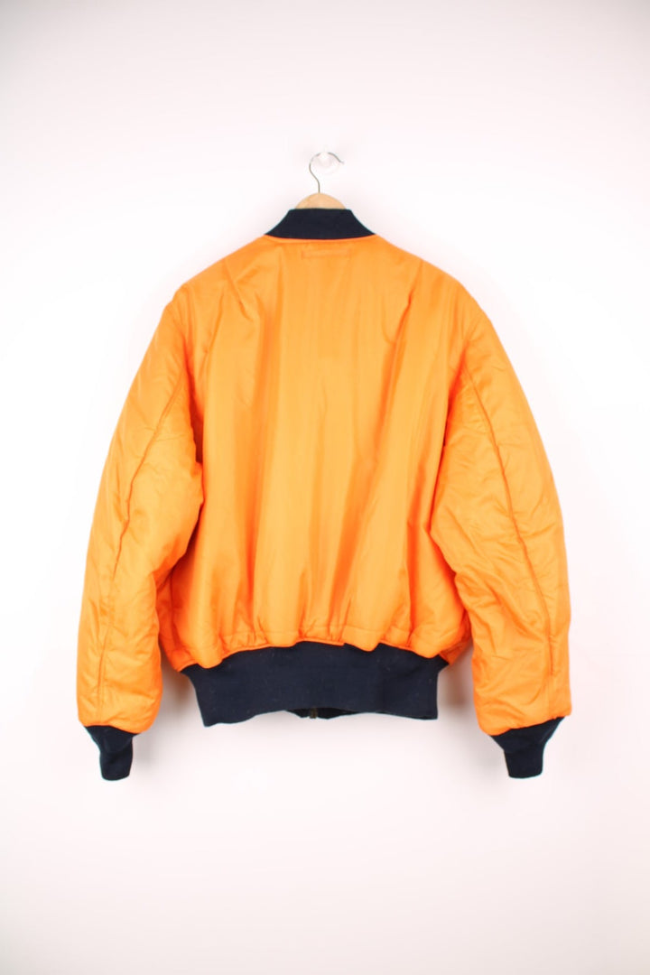 Alpha Industries MA-1 bomber flight reversible jacket in navy blue and orange with elasticated waistband and cuffs.