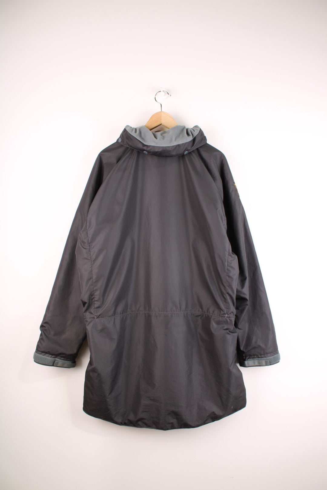 Paramo Nikwax waterproof jacket in black with multiple pockets, a retractable hood, and small logo patches on the sleeve and front.