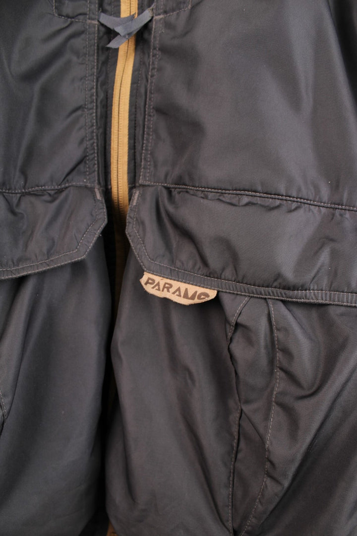 Paramo Nikwax waterproof jacket in black with multiple pockets, a retractable hood, and small logo patches on the sleeve and front.