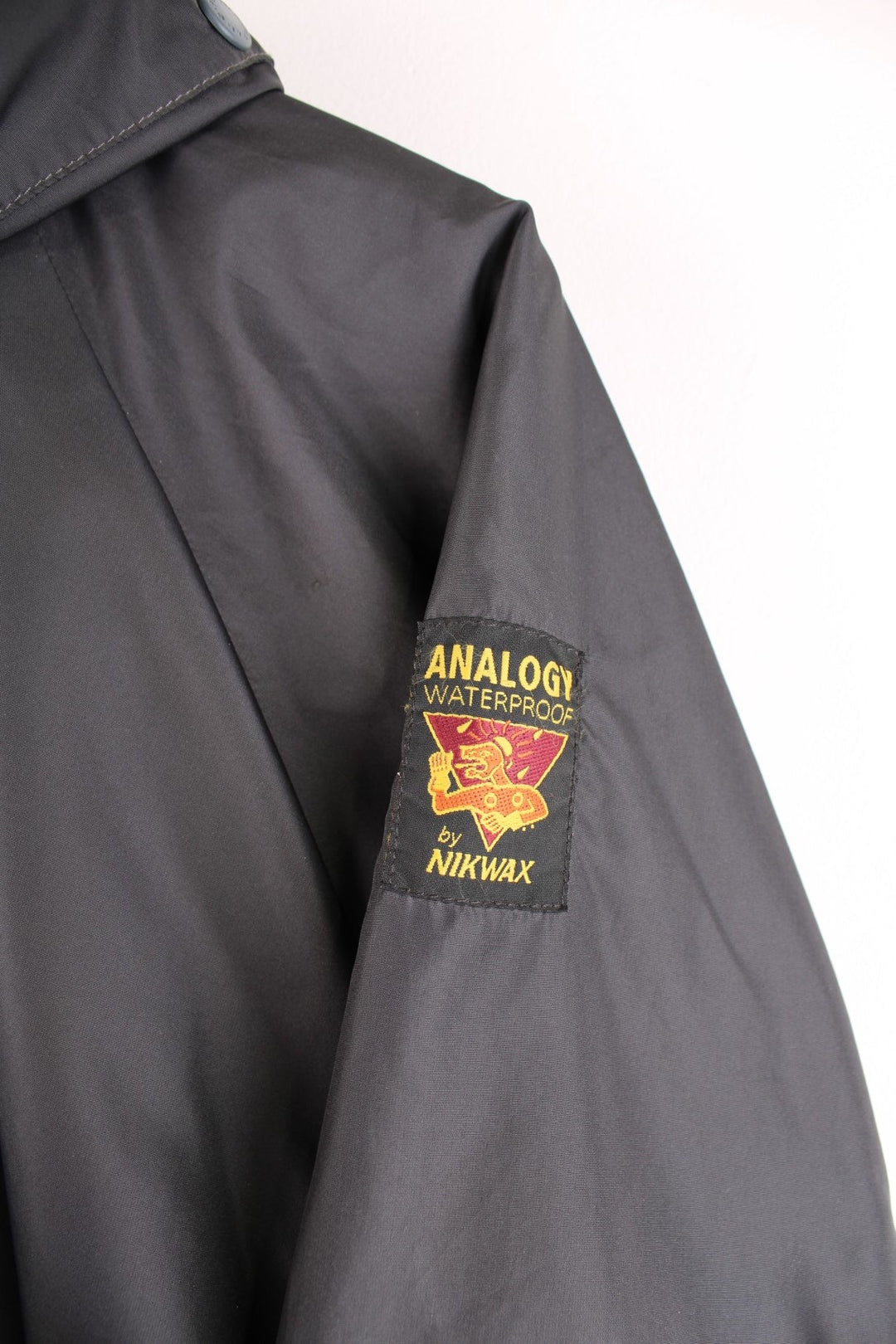 Paramo Nikwax waterproof jacket in black with multiple pockets, a retractable hood, and small logo patches on the sleeve and front.