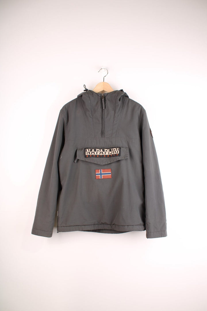 Napapijri hooded 1/4 zip pullover jacket in grey with front pouch pocket, side zip closure, various branded patches, and toggle adjusters in waistband.