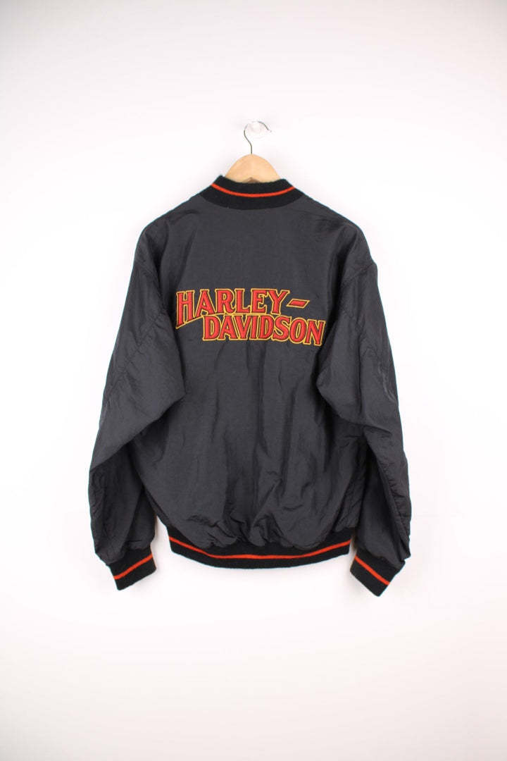 Vintage Harley Davidson shell/bomber jacket in black and orange. Features orange embroidered logo on the chest and spell out logo across the back.