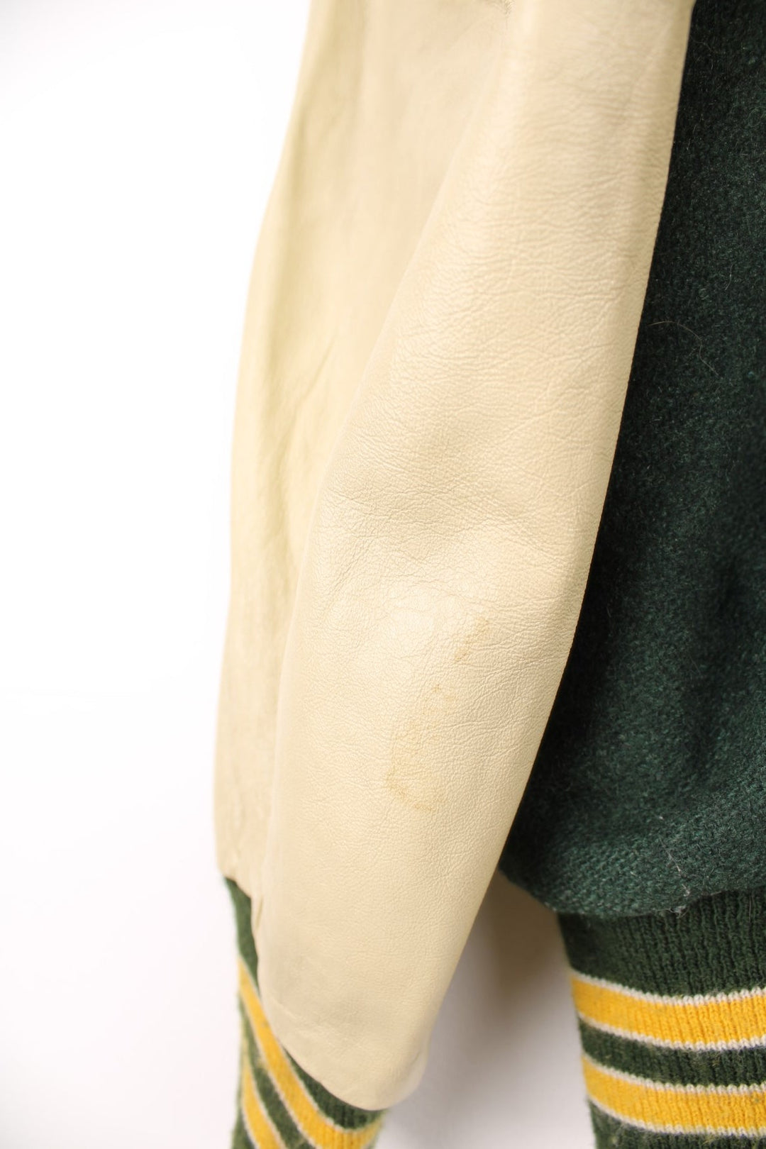 Vintage Delong, Placer Hillmen Wrestling varsity jacket in green and yellow, with beige leather sleeves and snap fastenings. Features embroidered letterman patch and numbers on the sleeve. 