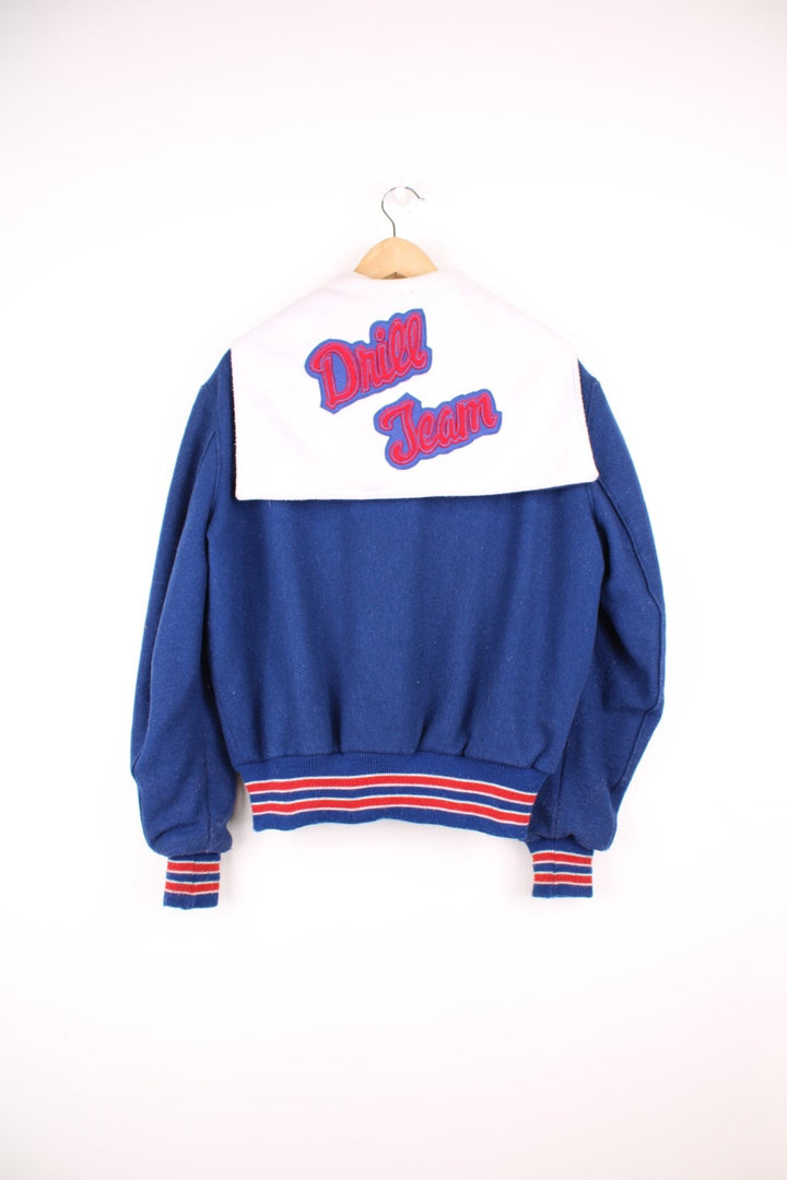 Vintage Delong varsity jacket in blue with red letterman patches, snap fastenings, and flap hood with embroidered "Drill Team".