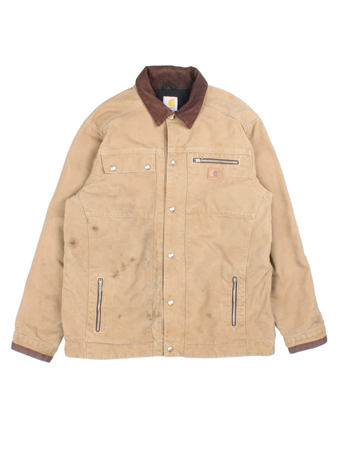 Carhartt J285 FRB Frontier Chore jacket in a tan colourway. The jacket has multiple pockets on the exterior with zip closures, and two interior pockets. There is a contrasting collar, and silver hardware. 