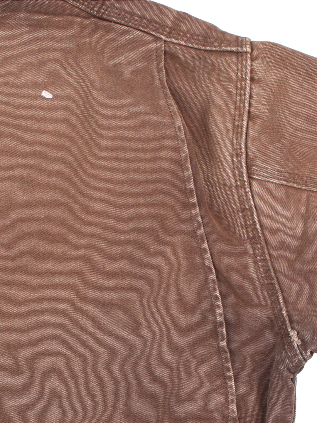 Vintage Carhartt Chore Coat in a brown colourway. The jacket has multiple exterior pockets, and one interior. It is blanket lined and has a corduroy collar. There is a leather logo patch stitched onto the front, and gold hardware.