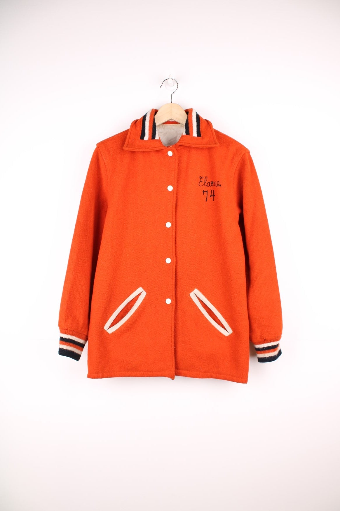 Vintage 70s Beavercreek orange wool varsity jacket. Features embroidered lettering on the back, and black and white stripe features on the cuffs and collar. 