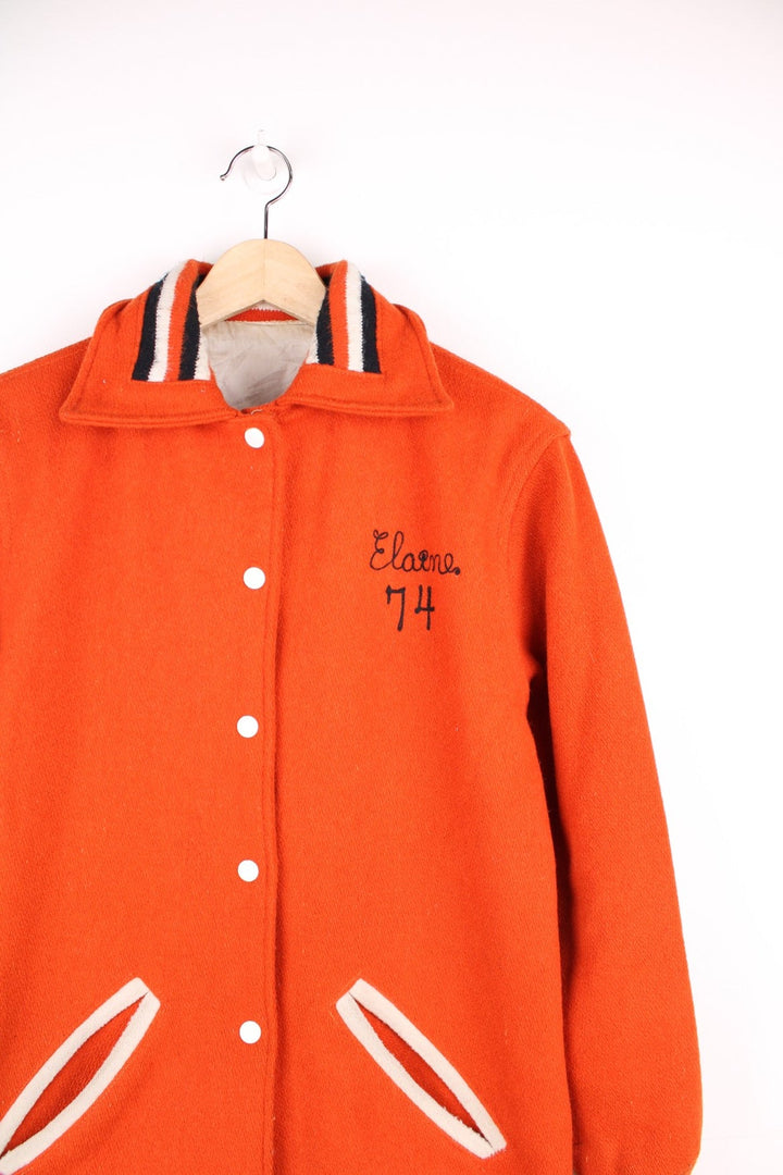 Vintage 70s Beavercreek orange wool varsity jacket. Features embroidered lettering on the back, and black and white stripe features on the cuffs and collar. 