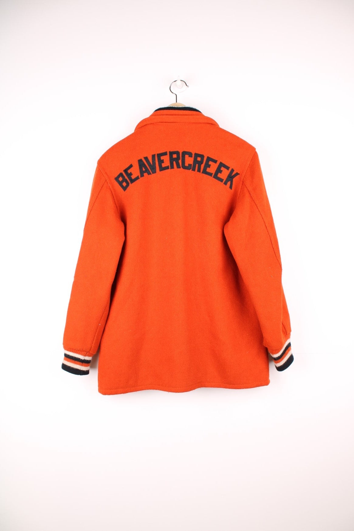 Vintage 70s Beavercreek orange wool varsity jacket. Features embroidered lettering on the back, and black and white stripe features on the cuffs and collar. 