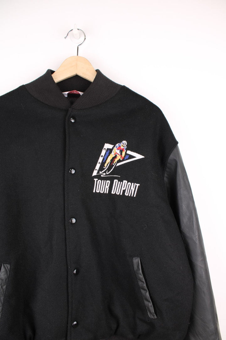 Vintage 1993 Tour DuPont black varsity jacket. Features embroidered logo on the front and back.