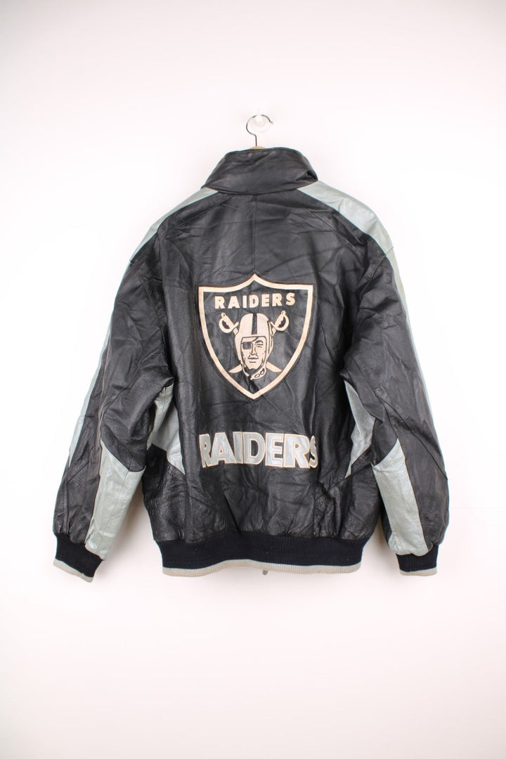 Vintage 90s Oakland Raiders leather jacket. Features embroidered badge on the front and back, and a pack away hood. 