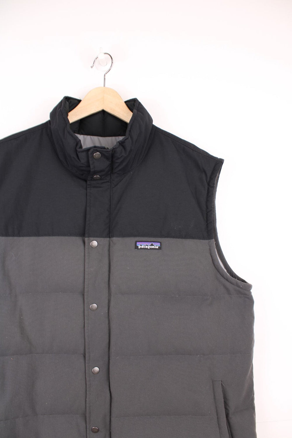 Grey and black Patagonia puffer gilet with zip and snap closure and slit pockets. 