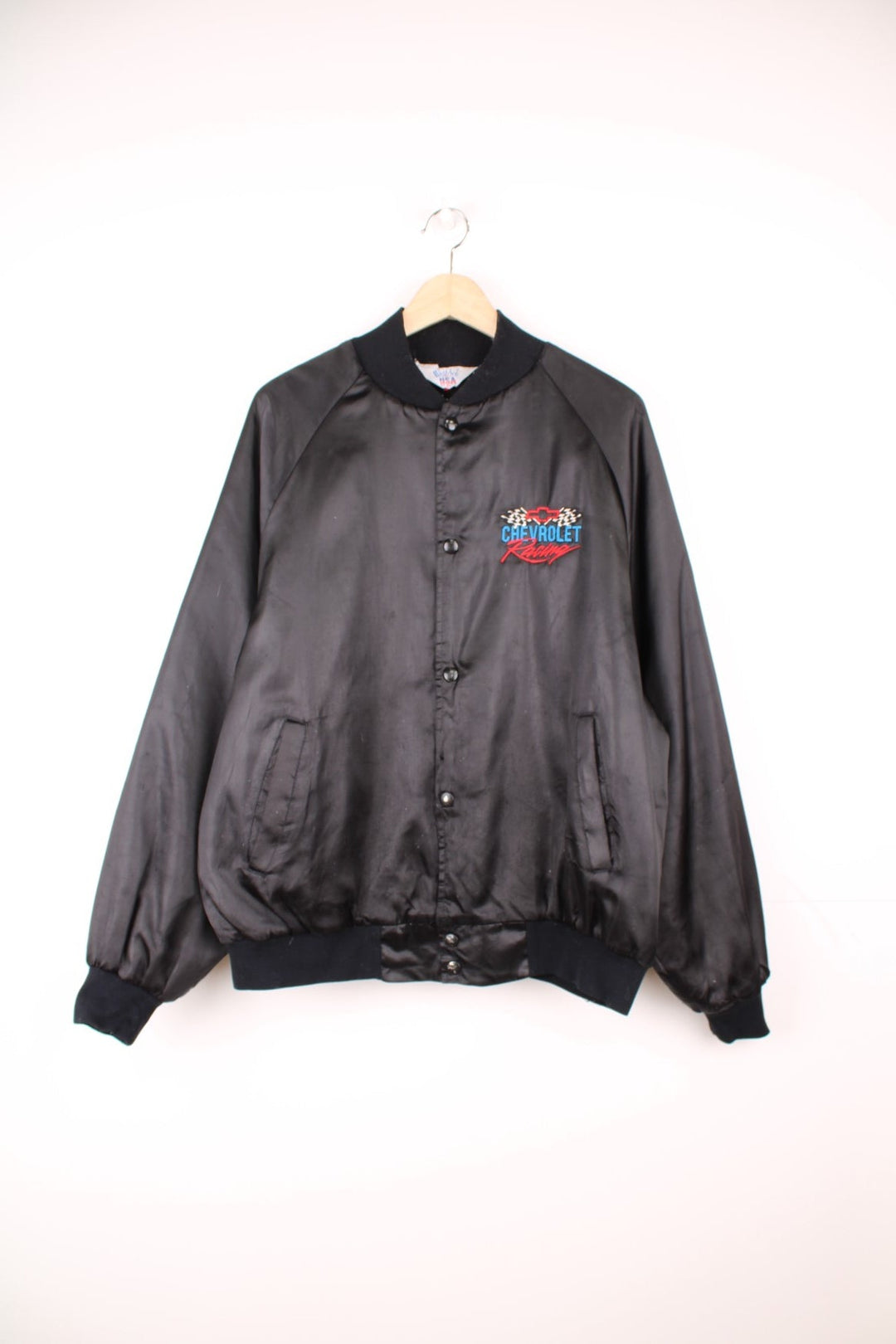 Black Chevrolet Racing bomber jacket by West Ark USA. Snap closure and front and back logo embroidery in red, white and blue. 