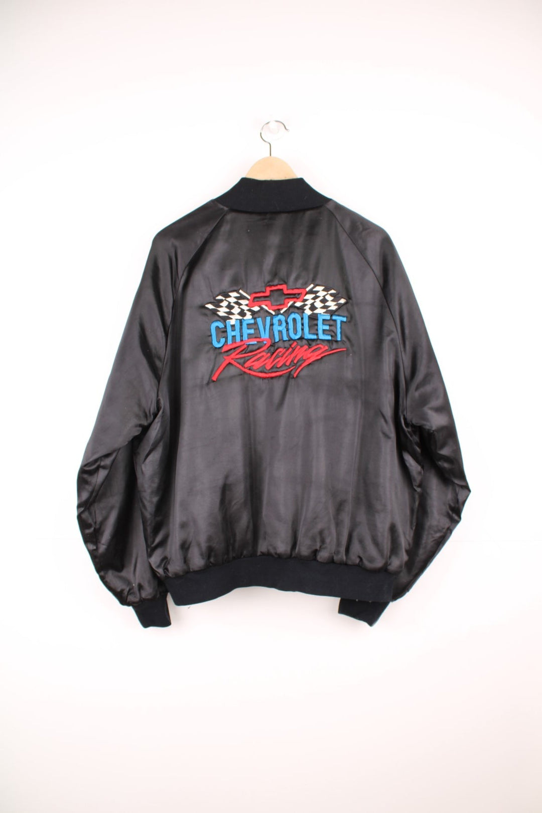 Black Chevrolet Racing bomber jacket by West Ark USA. Snap closure and front and back logo embroidery in red, white and blue. 