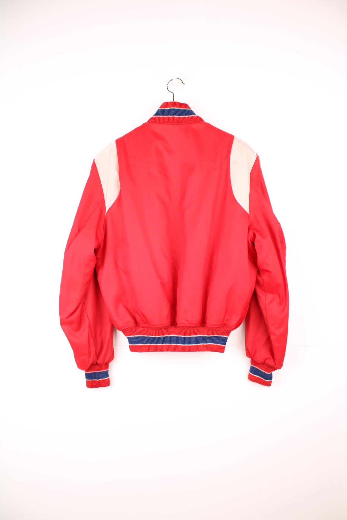 Red sherpa lined zip-through bomber jacket with blue and white accents, snap closure, slit pockets, sleeve embroidery and a large raised letter L patch.