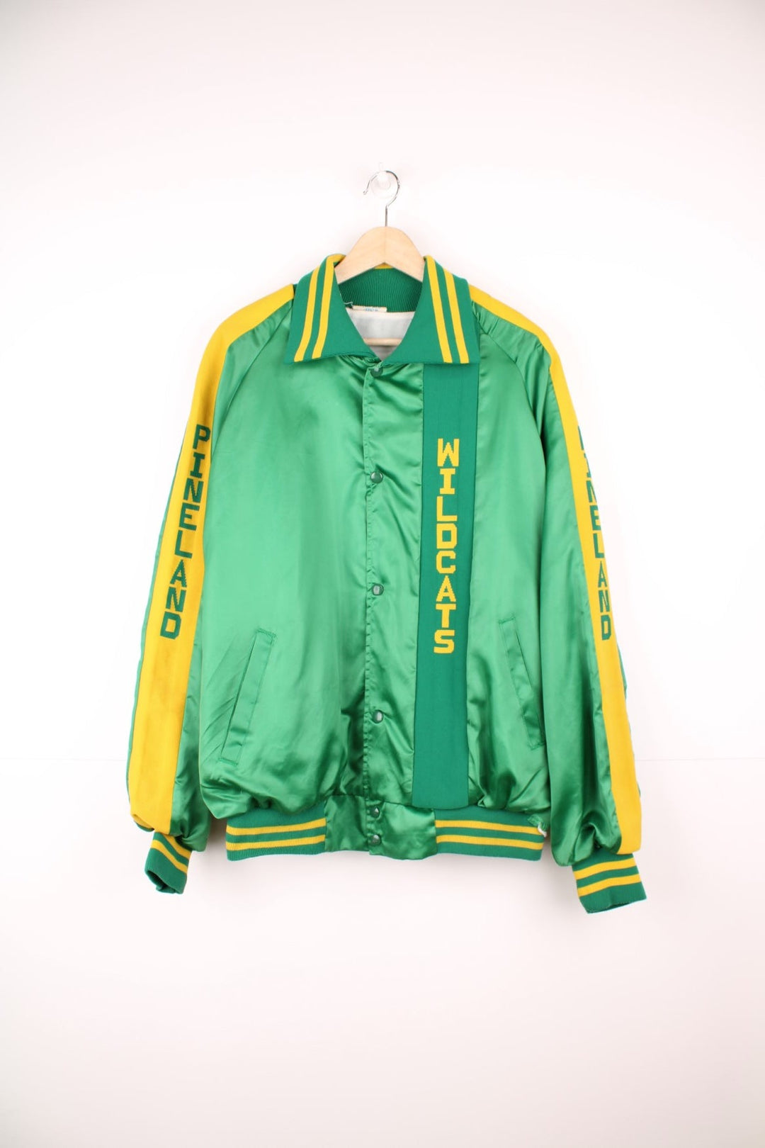 Green and yellow Pineland Wildcats bomber jacket with snap closure and side pockets.