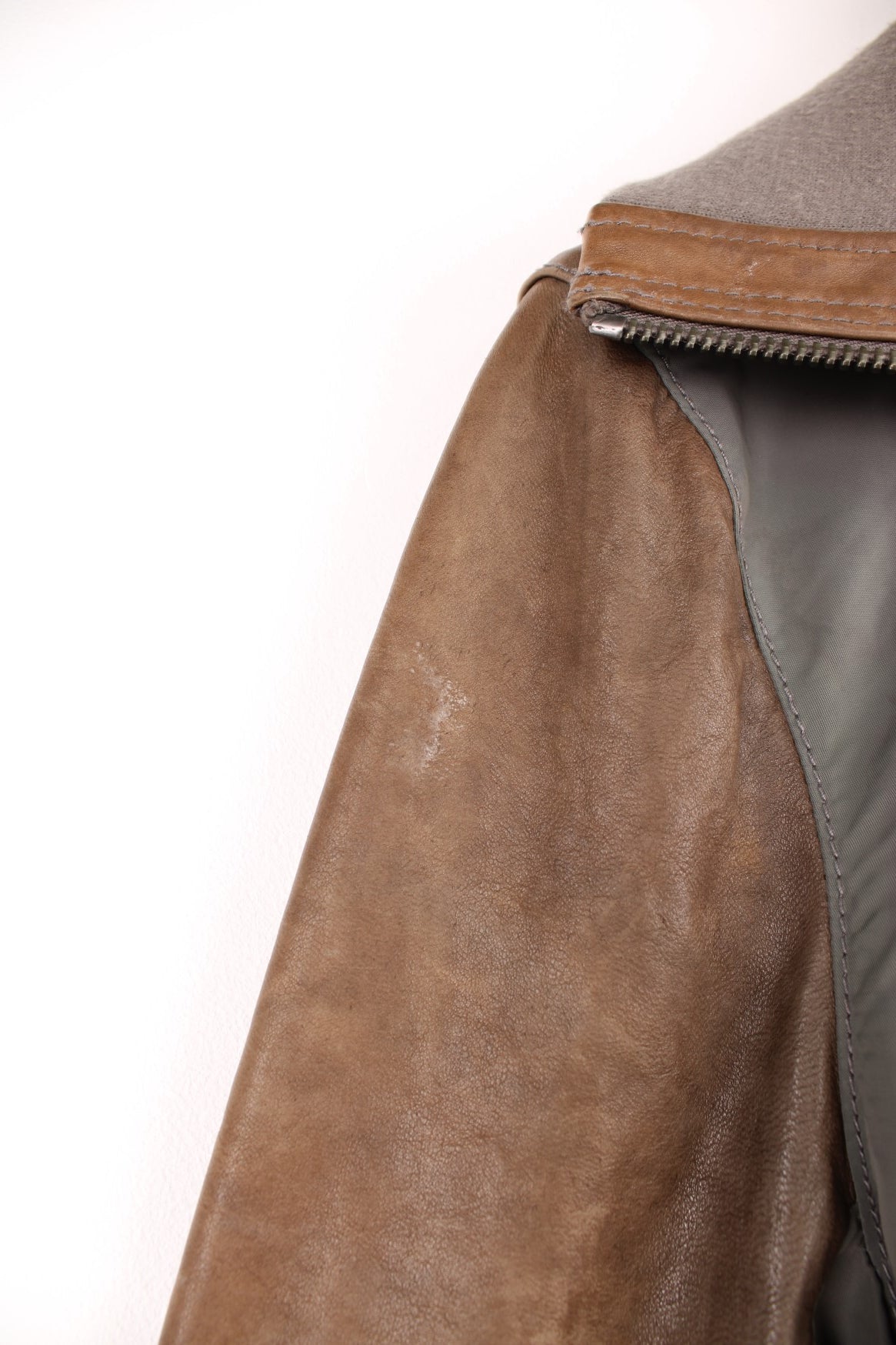 DKNY brown and grey panelled leather bomber jacket with zip closure and four pockets.  